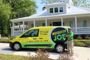Mosquito Joe service van parked in front of a home with a service professional beside it
